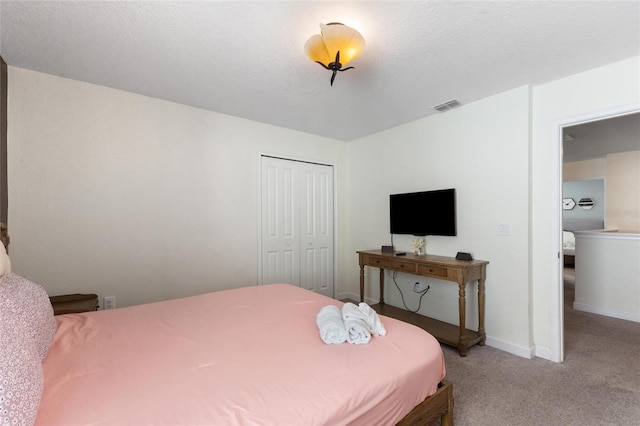 carpeted bedroom featuring baseboards, a textured ceiling, visible vents, and a closet