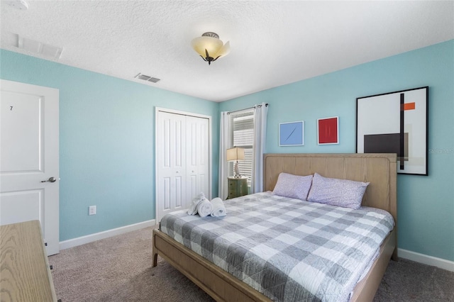 carpeted bedroom featuring a closet, visible vents, a textured ceiling, and baseboards