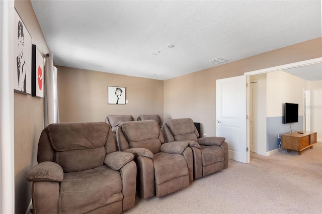 cinema featuring light carpet, visible vents, baseboards, and a textured ceiling