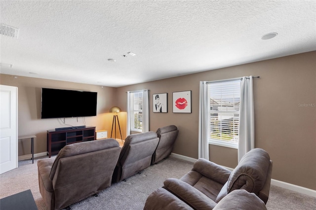 living room featuring light colored carpet, visible vents, a textured ceiling, and baseboards