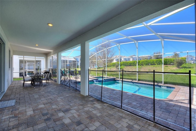 view of pool featuring a lanai, a patio area, a pool with connected hot tub, and outdoor dining space