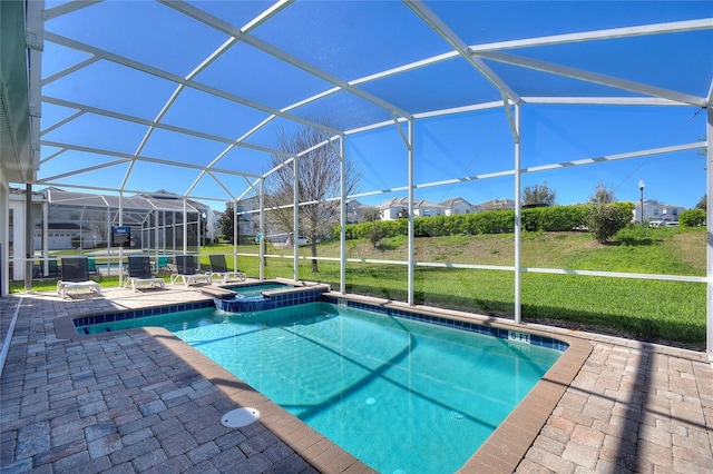 view of pool featuring glass enclosure, a pool with connected hot tub, a patio area, and a lawn