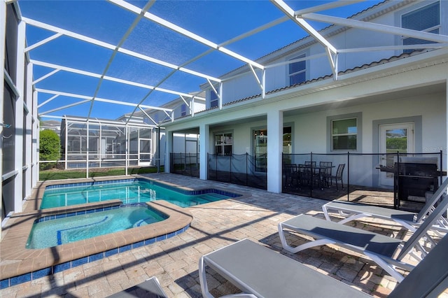 view of pool with a lanai, a patio area, and a pool with connected hot tub