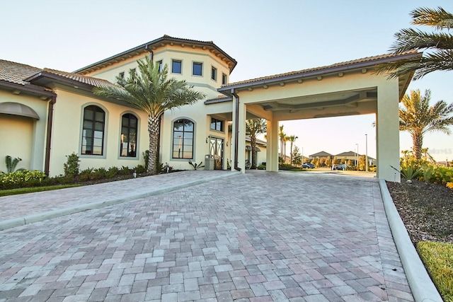 mediterranean / spanish house with driveway, a tiled roof, and stucco siding