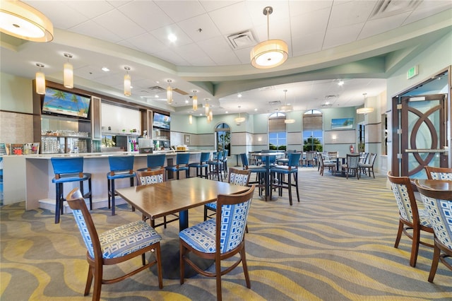 carpeted dining area featuring a paneled ceiling and visible vents