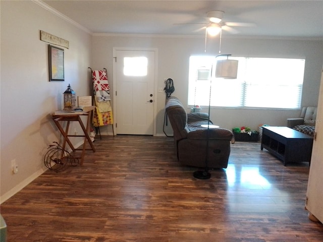 living area featuring ornamental molding, a ceiling fan, baseboards, and wood finished floors