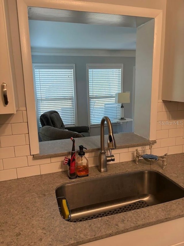 kitchen featuring stone counters, tasteful backsplash, and a sink