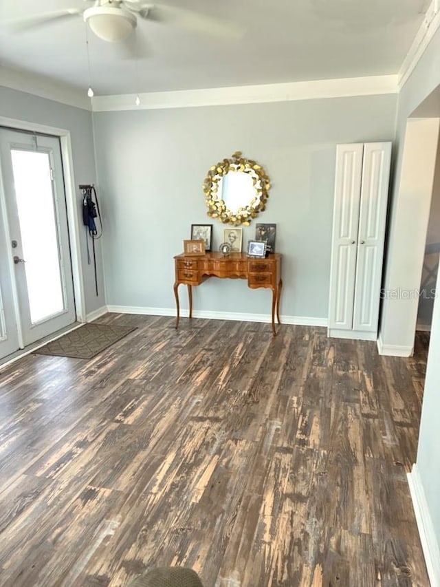 interior space featuring ceiling fan, ornamental molding, wood finished floors, and baseboards