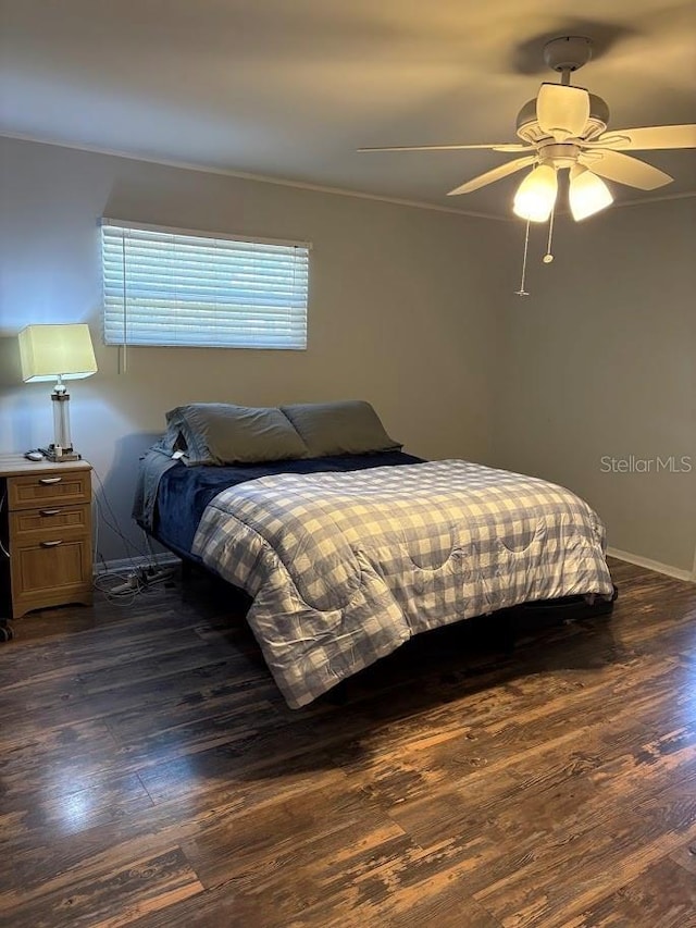 bedroom featuring dark wood-style flooring, a ceiling fan, and baseboards