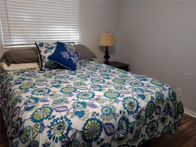 bedroom featuring baseboards and wood finished floors