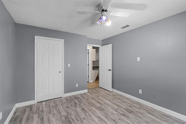 16017 Harbar Oaks Dr, Montverde, FL 34756 - unfurnished bedroom featuring a textured ceiling, wood finished floors, baseboards, and a ceiling fan