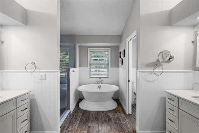 16017 Harbar Oaks Dr, Montverde, FL 34756 - full bath featuring wainscoting, wood finished floors, a freestanding tub, vanity, and a shower stall