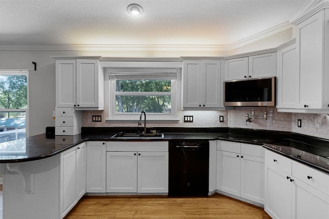 16017 Harbar Oaks Dr, Montverde, FL 34756 - kitchen with black appliances, a peninsula, a sink, healthy amount of natural light, and crown molding