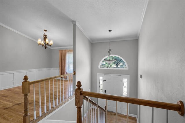 16017 Harbar Oaks Dr, Montverde, FL 34756 - entrance foyer featuring wood finished floors, a chandelier, crown molding, and a textured ceiling