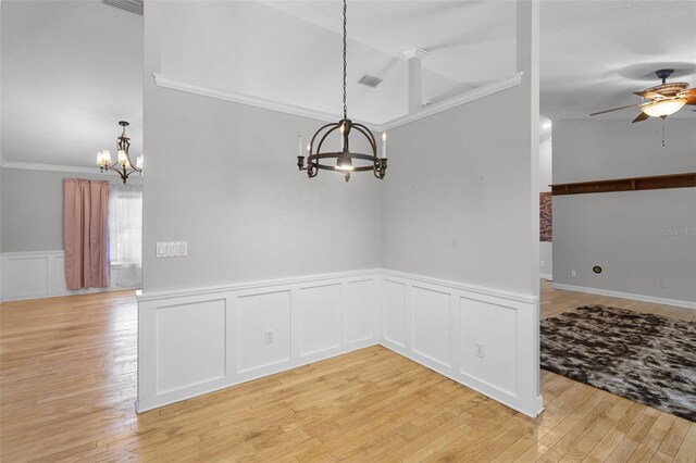16017 Harbar Oaks Dr, Montverde, FL 34756 - unfurnished dining area featuring a chandelier, ceiling fan, crown molding, light wood-style floors, and wainscoting