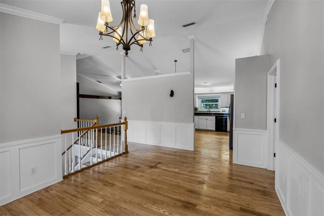 16017 Harbar Oaks Dr, Montverde, FL 34756 - hallway with an upstairs landing, crown molding, a decorative wall, a chandelier, and wood-type flooring