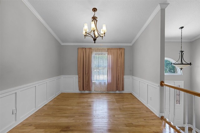 16017 Harbar Oaks Dr, Montverde, FL 34756 - unfurnished room with plenty of natural light, a chandelier, light wood-style floors, crown molding, and wainscoting