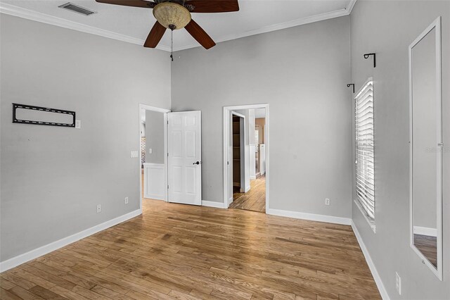 16017 Harbar Oaks Dr, Montverde, FL 34756 - unfurnished bedroom featuring a towering ceiling, baseboards, crown molding, light wood-type flooring, and a ceiling fan