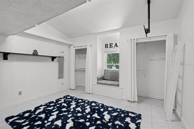 16017 Harbar Oaks Dr, Montverde, FL 34756 - unfurnished bedroom featuring two closets, marble finish floors, baseboards, and vaulted ceiling