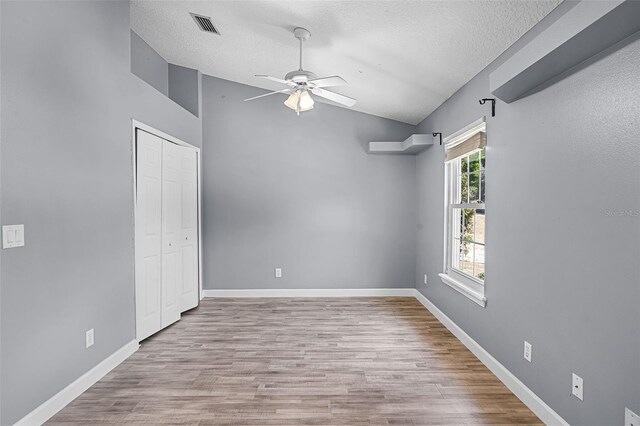 16017 Harbar Oaks Dr, Montverde, FL 34756 - unfurnished bedroom with lofted ceiling, a textured ceiling, wood finished floors, baseboards, and a closet