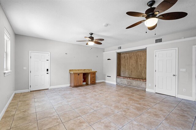 16017 Harbar Oaks Dr, Montverde, FL 34756 - unfurnished living room featuring a ceiling fan, light tile patterned flooring, a textured ceiling, and baseboards