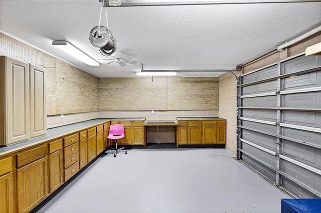 16017 Harbar Oaks Dr, Montverde, FL 34756 - garage featuring ceiling fan, a desk, and wood walls