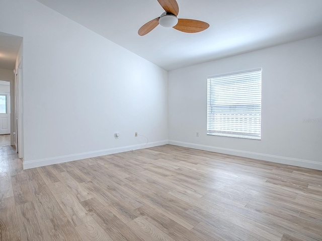 spare room featuring a ceiling fan, baseboards, and light wood-type flooring