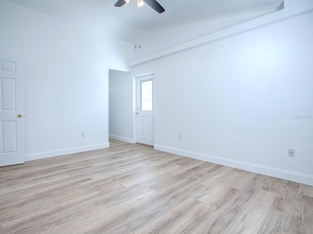 spare room with high vaulted ceiling, baseboards, light wood-style floors, and a ceiling fan