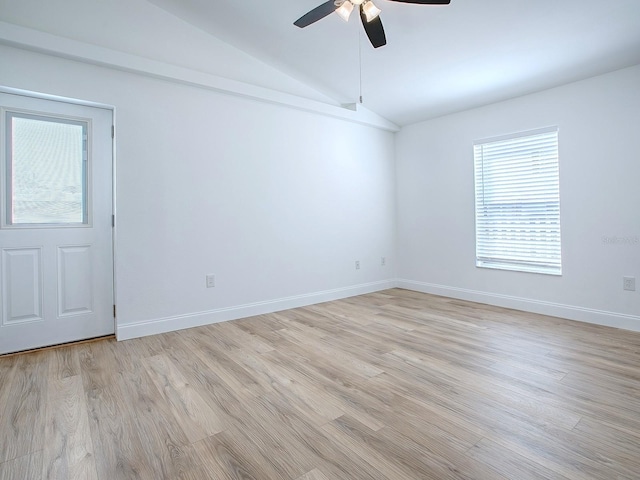 empty room with a ceiling fan, lofted ceiling, light wood-style floors, and baseboards