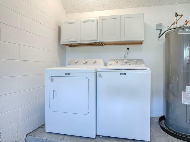 laundry area featuring cabinet space, concrete block wall, water heater, and washer and clothes dryer