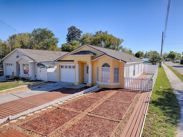 view of front of property with a gate, fence, driveway, stucco siding, and a garage