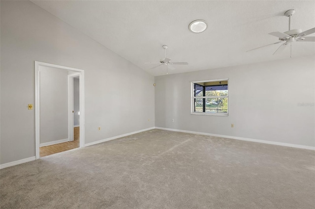 carpeted spare room featuring ceiling fan, baseboards, and vaulted ceiling