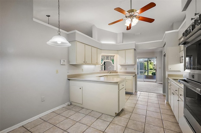 kitchen featuring light tile patterned floors, light countertops, ornamental molding, oven, and a peninsula