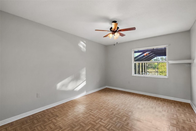 empty room featuring a ceiling fan and baseboards