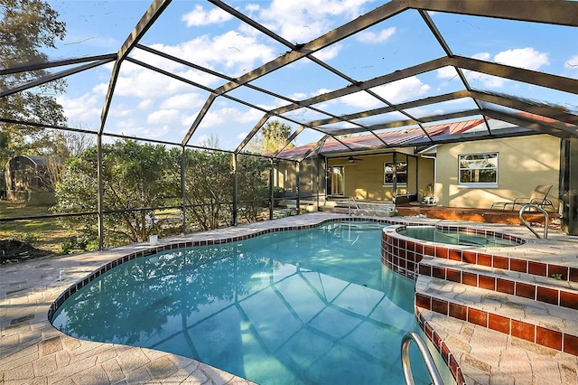 view of pool with a lanai, a pool with connected hot tub, and a patio