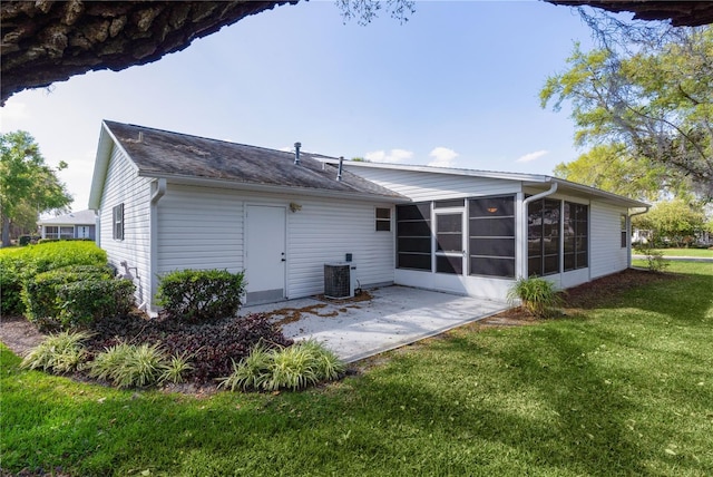 back of property with central AC unit, a lawn, a patio, and a sunroom