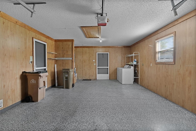 garage with a garage door opener and separate washer and dryer