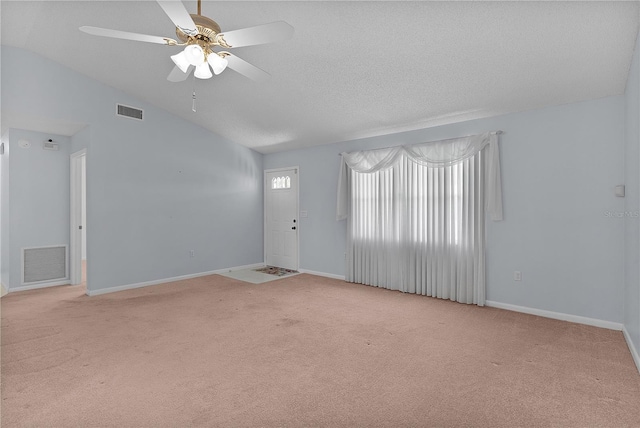 unfurnished living room featuring visible vents, carpet, a ceiling fan, and vaulted ceiling