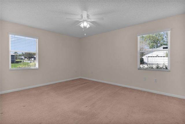 carpeted spare room with baseboards, a textured ceiling, and ceiling fan