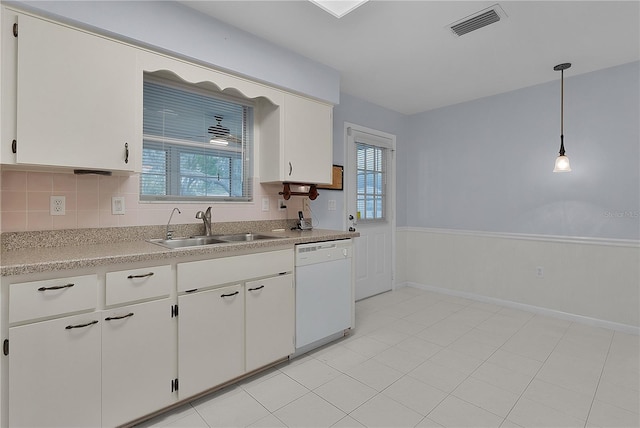 kitchen featuring visible vents, dishwasher, light countertops, white cabinets, and a sink