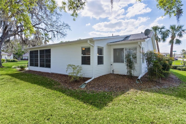 rear view of house with a yard and a sunroom