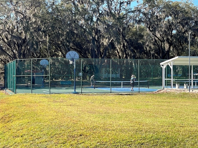 view of sport court featuring community basketball court, a lawn, and fence