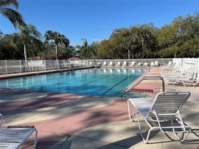 pool with a patio and fence