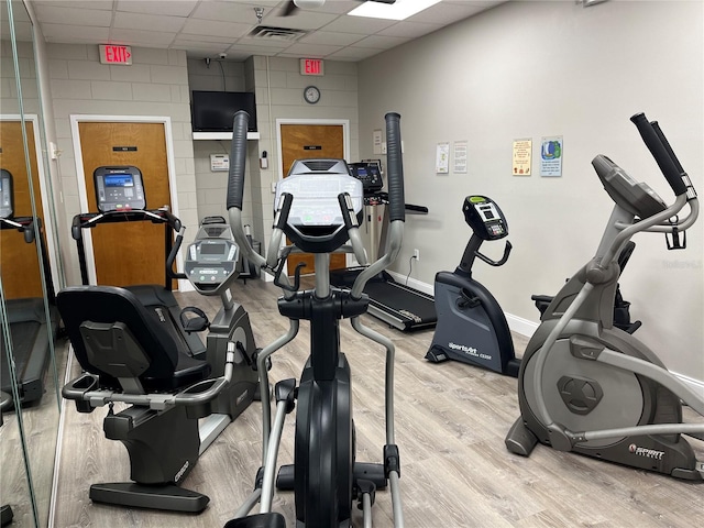 gym with a drop ceiling, visible vents, baseboards, and wood finished floors