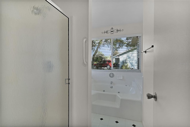 bathroom featuring tile patterned floors, a stall shower, and a whirlpool tub