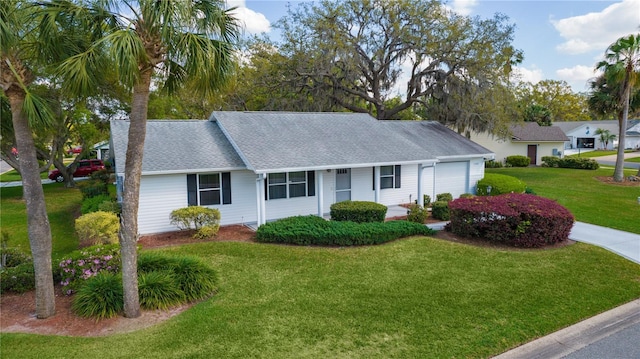 single story home with a front yard, an attached garage, and roof with shingles