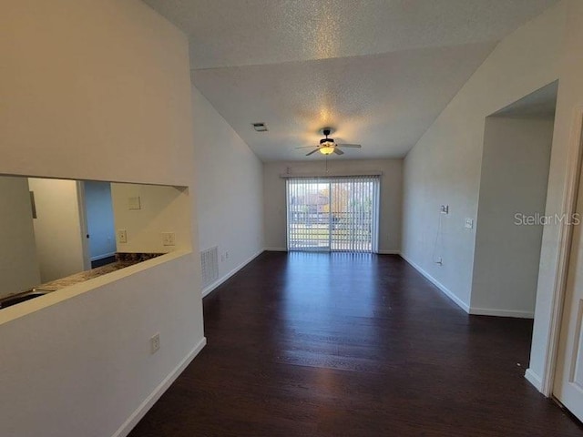 unfurnished living room featuring a ceiling fan, visible vents, dark wood-style flooring, and a textured ceiling