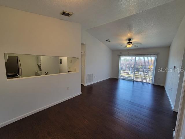 unfurnished living room with lofted ceiling, wood finished floors, and visible vents