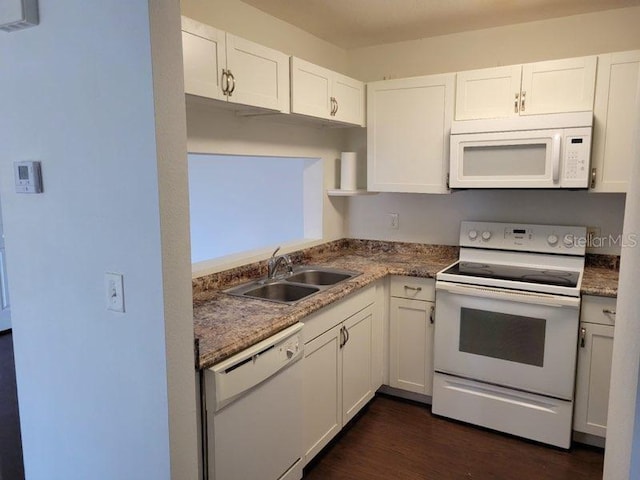 kitchen with white appliances, white cabinets, and a sink