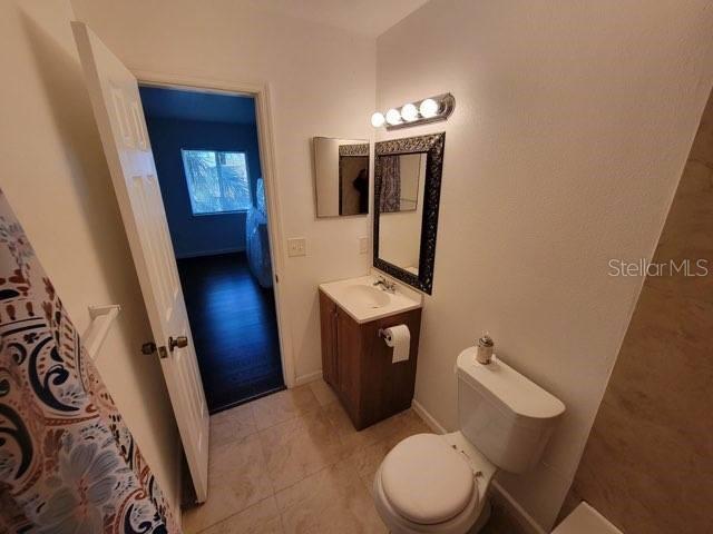 bathroom featuring baseboards, vanity, and toilet